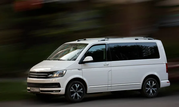 Hareket bulanık arkaplanda Volkswagen beyaz minibüsü.