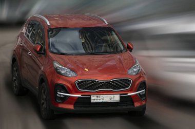 Hareket bulanık arkaplanda Kia kırmızı araba.