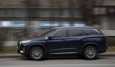 Hareket bulanıklığı olan arka planda Jetour siyah geçiş aracı.