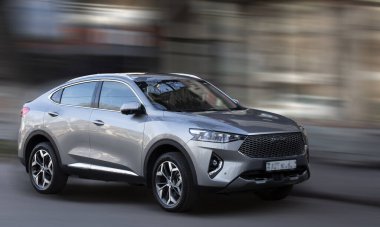 Arka planda bulanık hareket eden gri bir araba..