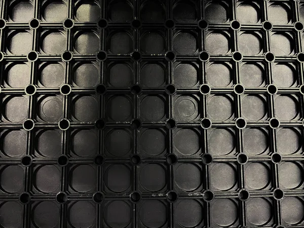 Metalden yapılmış simetrik şekil, koyu boya ile boyanmış.