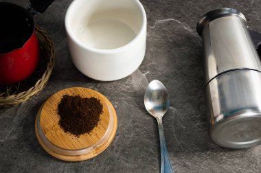 kahve ve kahve aksesuarları taş masa arkasında.