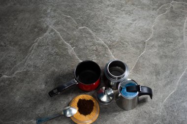 kahve ve kahve aksesuarları taş masa arkasında.