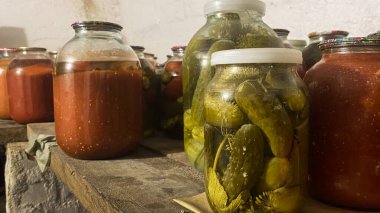 Uzun vadeli depolama için yiyeceklerle dolu bir kiler. Ahşap raflarda sebzeli kavanozlar