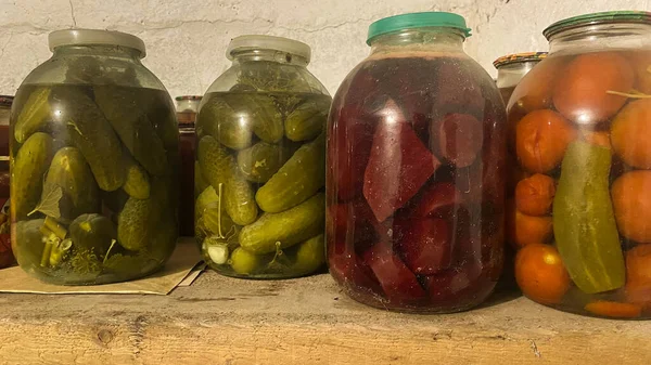 Uzun vadeli depolama için yiyeceklerle dolu bir kiler. Ahşap raflarda sebzeli kavanozlar