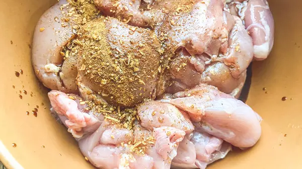 marinating meat in a clay pot, close-up with various spices