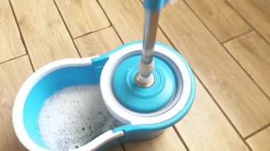 Evi temizliyorum. Döşemeleri temizliyorum. Islak temizleme. Su ve deterjan dolu kova.