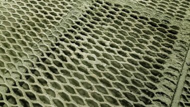 Altıgen hücreleri olan ızgaralı bir yüzeye yakın çekim, düzensizlikleri olan açık gri yüzey