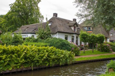 GIETHOORN, NETHERLANDS - evlerin ve bahçelerin tipik Hollanda ilçesi