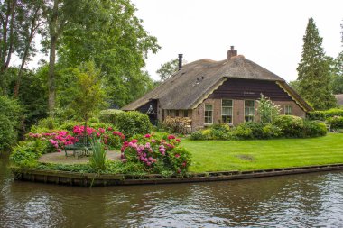 GIETHOORN, NETHERLANDS - evlerin ve bahçelerin tipik Hollanda ilçesi