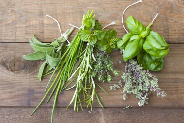 Ahşap arka planda taze toplanmış otlar.