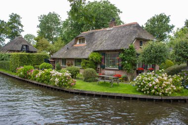 GIETHOORN, NETHERLANDS - evlerin ve bahçelerin tipik Hollanda ilçesi