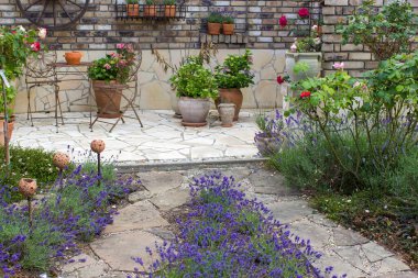 Akdeniz tarzında bahçede güzel bir yer. Güller ve lavanta çiçekleri.