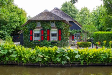 GIETHOORN, NETHERLANDS - evlerin ve bahçelerin tipik Hollanda ilçesi