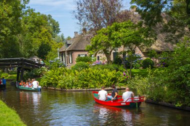 GIETHOORN, NETHERLANDS - 05 Ağustos 2015: Giethoorn 'daki bir kanalda tekne gezisinde bilinmeyen ziyaretçiler. Güzel evler ve bahçıvanlık şehri 