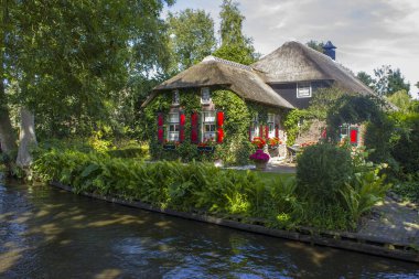 GIETHOORN, NETHERLANDS - evlerin ve bahçelerin tipik Hollanda ilçesi