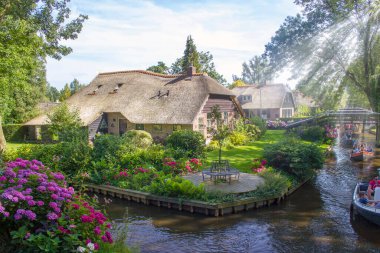 GIETHOORN, NETHERLANDS - 05 Ağustos 2015: Giethoorn 'daki bir kanalda tekne gezisinde bilinmeyen ziyaretçiler. Güzel evler ve bahçıvanlık şehri 