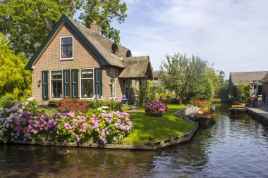 GIETHOORN, NETHERLANDS - evlerin ve bahçelerin tipik Hollanda ilçesi