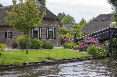 GIETHOORN, NETHERLANDS - evlerin ve bahçelerin tipik Hollanda ilçesi