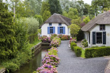 GIETHOORN, NETHERLANDS - evlerin ve bahçelerin tipik Hollanda ilçesi