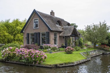 GIETHOORN, NETHERLANDS - evlerin ve bahçelerin tipik Hollanda ilçesi