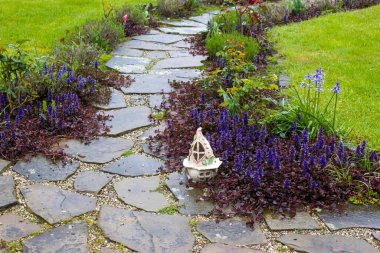 Taş döşeli bahçe yolu ve çiçekler - ilkbahar zamanı