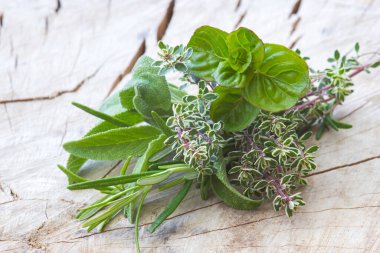 Ahşap arka planda taze toplanmış otlar.