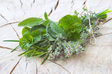 Ahşap arka planda taze toplanmış otlar.