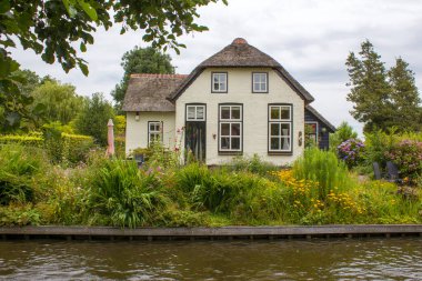 GIETHOORN, NETHERLANDS - evlerin ve bahçelerin tipik Hollanda ilçesi
