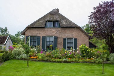 GIETHOORN, NETHERLANDS - evlerin ve bahçelerin tipik Hollanda ilçesi