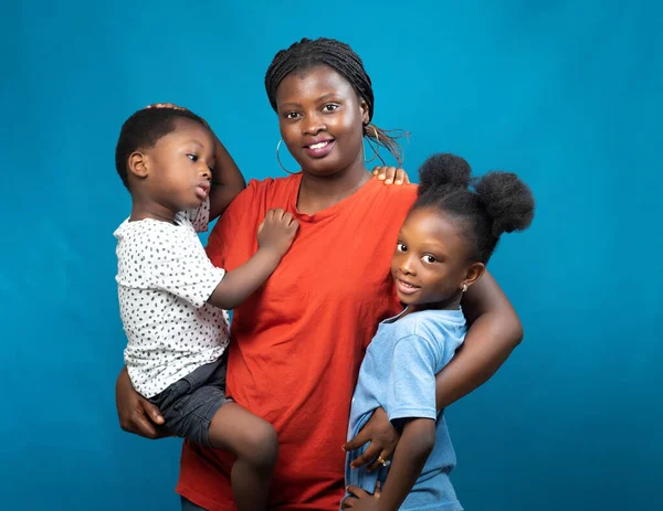 Stock image Happy African family from Nigeria consisting of a mother, aunt or guardian, carrying the children, a boy and girl child in her hands