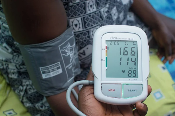 stock image A care giver checking blood pressure of a medical patient with an advance technological device