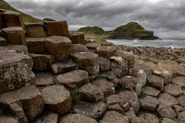 İrlanda 'daki Giants Causeway' in bazalt sütunları dramatik gökyüzü altında.