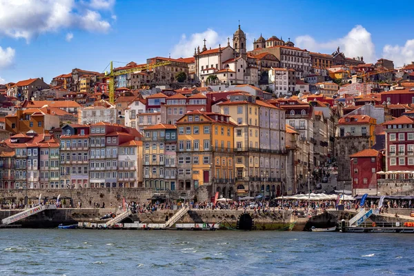 Porto, Portekiz - 11 Ağustos 2019: Douro Nehri 'nin karşısındaki eski şehrin ufuk çizgisi. Ribeira tarihi bölgesinin ön görüntüsü. Renkli evler. Porto, uluslararası alanda keşfedilecek bir hedef olarak tanınıyor ve tercih edilen bir seçim.
