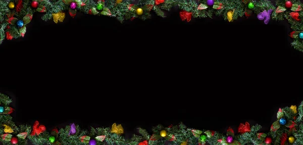 クリスマスの枠組み ボールと木の枝と挨拶のテキストのためのスペースで飾られた黒い背景 — ストック写真