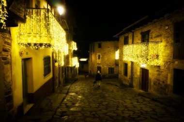 Puebla de Sanabria, İspanya - 06 Aralık 2021: Ortaçağ 'ın Puebla de Sanabria kentindeki insanlar Noel ışıklarının keyfini çıkarıyorlar. Zamora. İspanya. Puebla de Sanabria, İspanya 'nın en güzel şehirlerinden biridir.