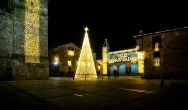 Puebla de Sanabria, İspanya - 06 Aralık 2021: Ortaçağ 'ın Puebla de Sanabria kentindeki insanlar Noel ışıklarının keyfini çıkarıyorlar. Zamora. İspanya. Aydınlık mesajda 