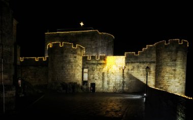 Puebla de Sanabria, İspanya - 06 Aralık 2021: Ortaçağ 'ın Puebla de Sanabria kentindeki insanlar Noel ışıklarının keyfini çıkarıyorlar. Zamora. İspanya. Puebla de Sanabria, İspanya 'nın en güzel şehirlerinden biridir.