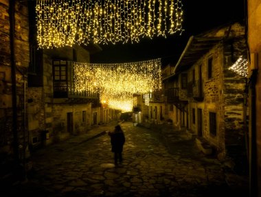 Puebla de Sanabria, İspanya - 06 Aralık 2021: Ortaçağ 'ın Puebla de Sanabria kentindeki insanlar Noel ışıklarının keyfini çıkarıyorlar. Zamora. İspanya. Puebla de Sanabria, İspanya 'nın en güzel şehirlerinden biridir.
