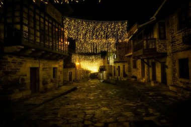 Puebla de Sanabria, İspanya - 06 Aralık 2021: Ortaçağ 'ın Puebla de Sanabria kentindeki insanlar Noel ışıklarının keyfini çıkarıyorlar. Zamora. İspanya. Puebla de Sanabria, İspanya 'nın en güzel şehirlerinden biridir.