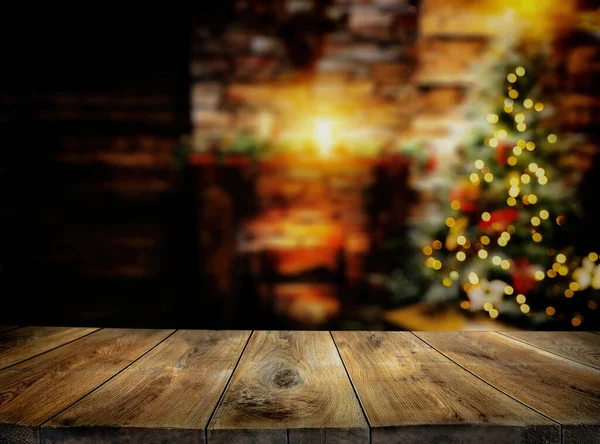 Boş ahşap masa arkaplanı ve bulanık Noel ağacı. ve şömine..