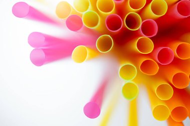 Beyaz arkaplanda renkli plastik pipetler