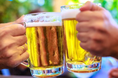 Two friends toasting with glasses of beer clipart