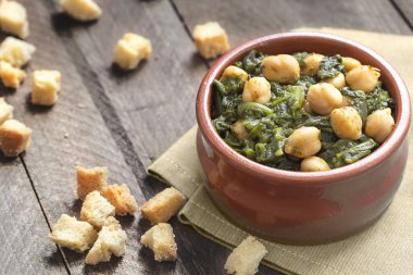 Kırsal ahşap arka planda nohut ve ıspanak yahnisi. İspanyol mutfağı.