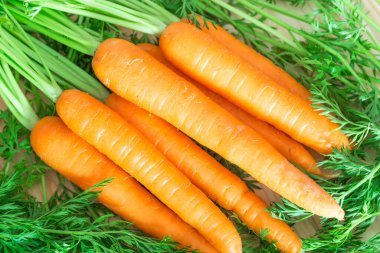 Fresh and sweet carrots on wooden table. clipart