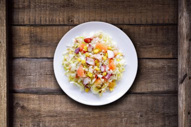 Pirinçli soğuk yaz salatası, kakaolu mısır ve sebzeler kırsal ahşap masada. Sağlıklı gıda kavramı.