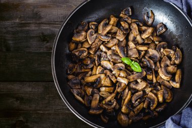 Lezzetli ve sağlıklı kızarmış mantar şampiyonu zeytin yağı, soğan, garli, kırmızı biber ve fesleğen.