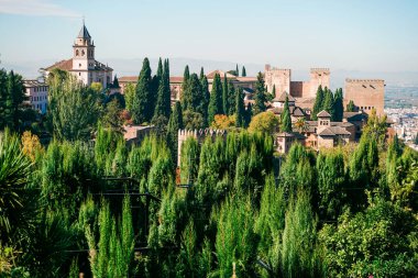 Alhambra Sarayı, Granada, İspanya. Güneşli bir günde bereketli selvi ağaçlarının üzerinde yükselen Majestic Alhambra Sarayı, Granada, Endülüs, İspanya