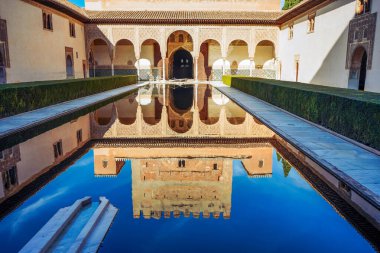 Alhambra Sarayı, Granada, İspanya. Süslü kemerler ve Alhambra Sarayı 'nın duvarları Granada, İspanya' da ünlü bir avlu olan Los Angeles 'ın durgun sularına mükemmel bir şekilde yansıyor.
