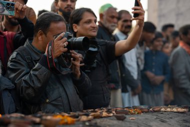 Photographer capturing portraits. URS Hazrat Madhu Lal Hussain. 02 March 2024 clipart